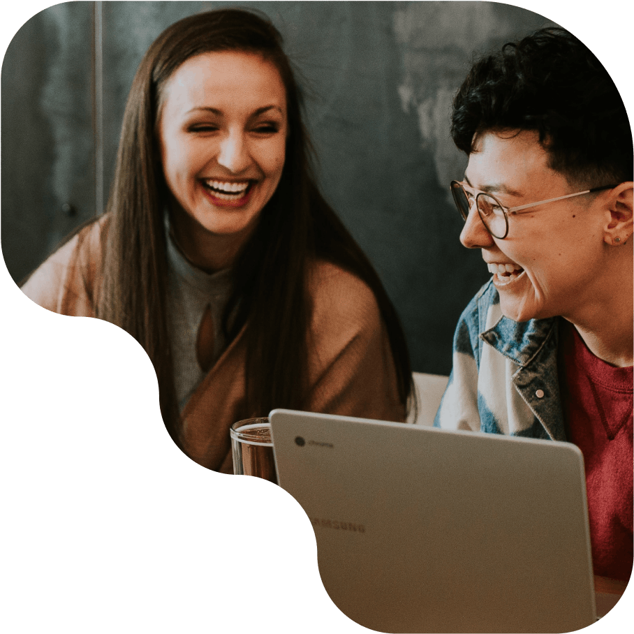 Two smiling women at a computer 